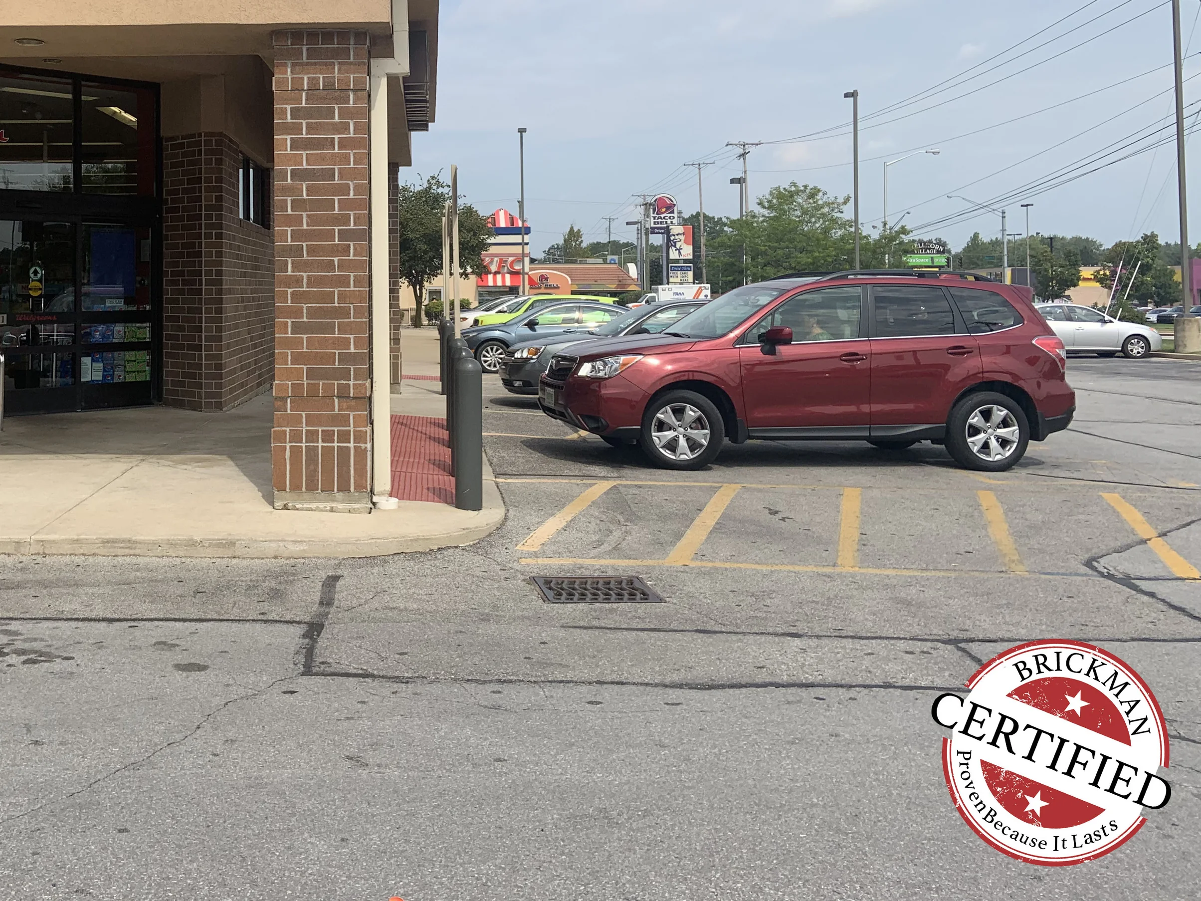 The entrance corner of the store in 2019, the brick column beside the doors reading as the same red brown range as the wall it stands against
