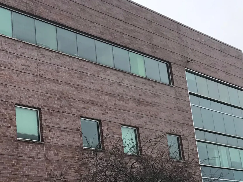 The same elevation in 2021, the brick an even red range from the window band down past the square windows to the glazed bay