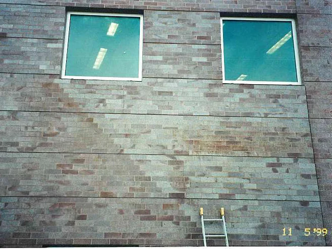 The large wall in 1999, a broad diagonal band of off color brick running across the courses under two square windows, with a ladder standing against it