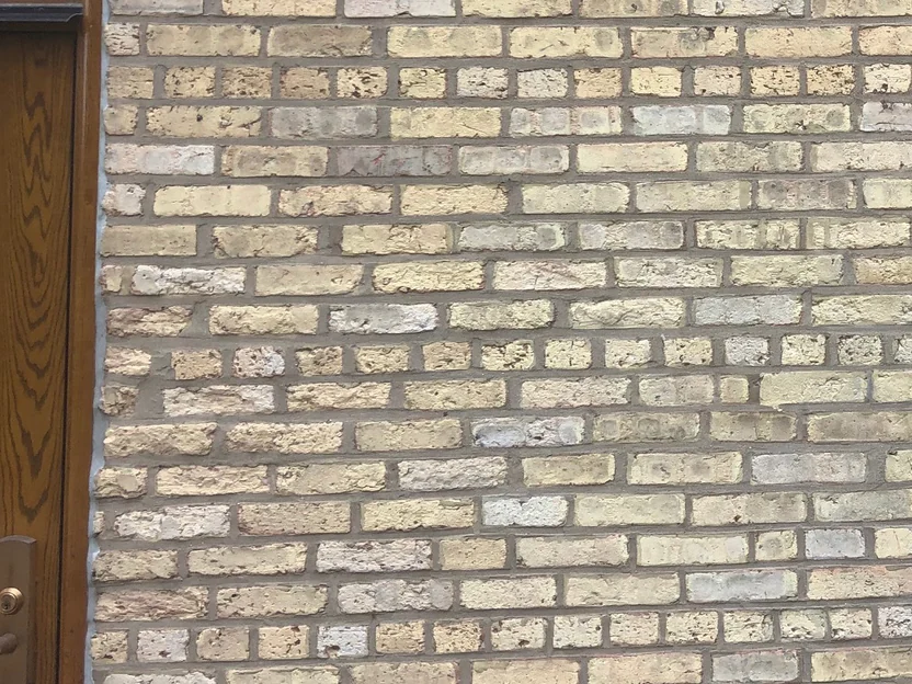 Close on the wall beside an oak entrance door in 2019, cream, grey and pale pink units mixed unit by unit across the courses