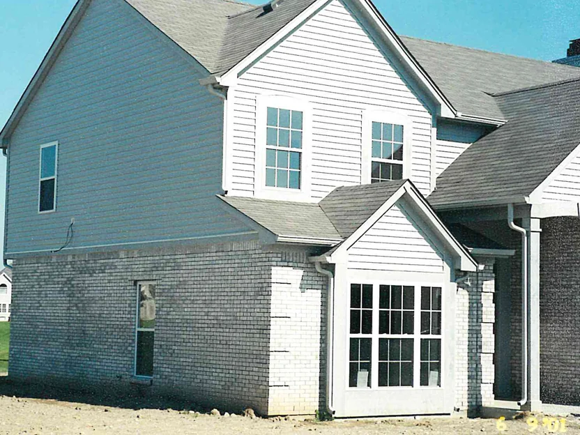 The gable end and bay window of the house in 2001, the brick blotched with pale and dark areas across the whole wall