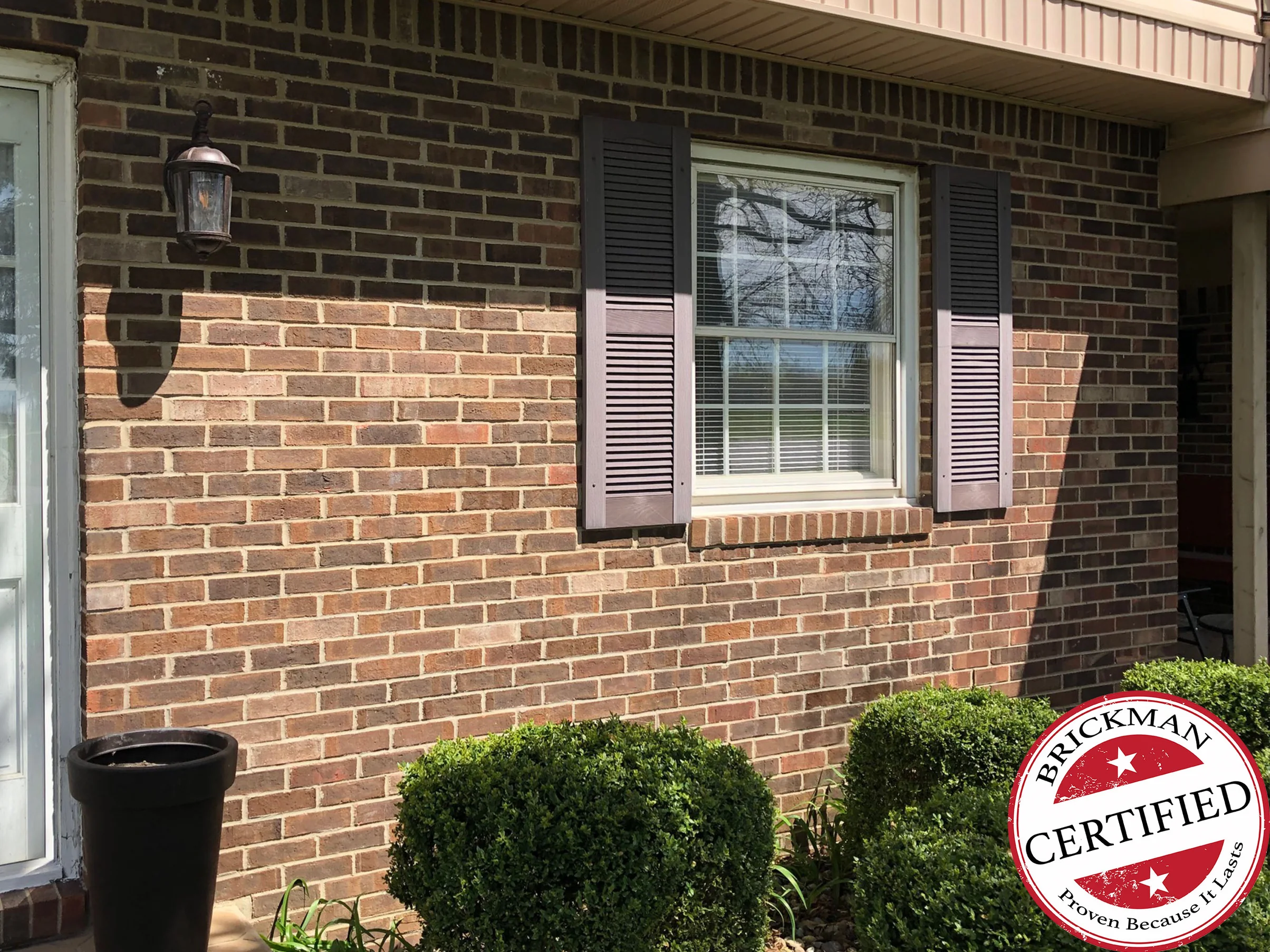 The same wall in 2019 with shutters now on the window, the lighter units still running through the brick from the door across to the porch