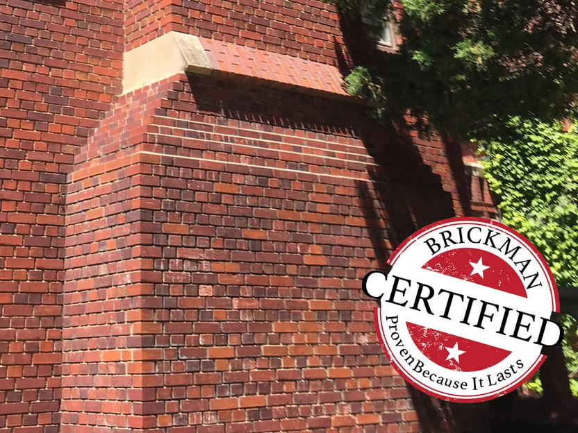 The foot of the chimney breast in 2019, the brick one even red across the corbelled offset, with the certification stamp in the corner