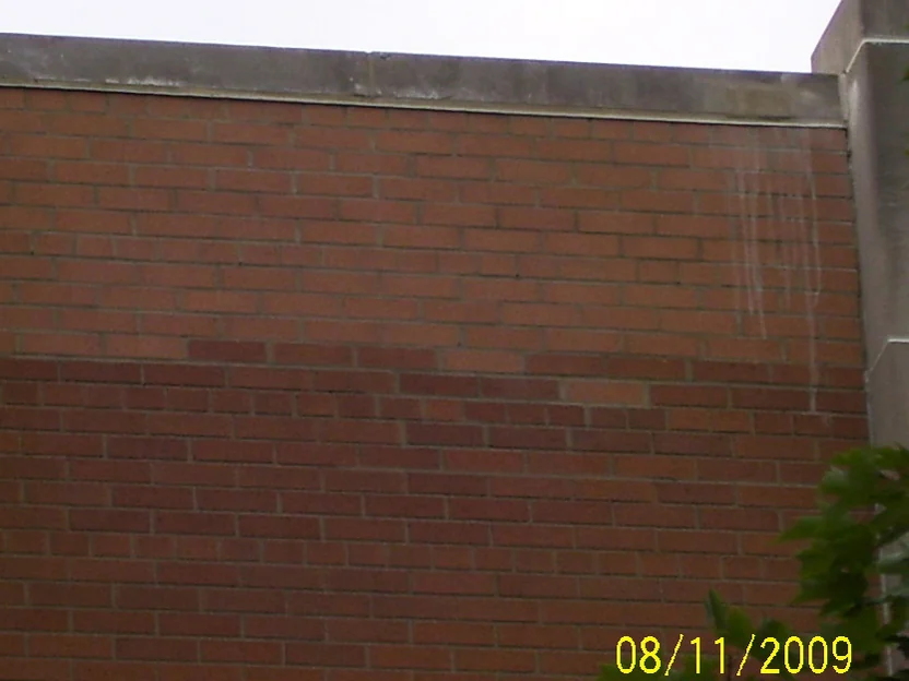 A section of wall beside a concrete pier in 2009, the upper courses of brick a lighter and pinker tone than the courses below, with a camera date of 08/11/2009