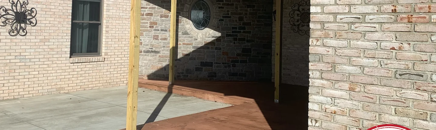 The covered patio of the Kentucky house in 2020, the pale brick of the wall on the left and the whitewashed-look brick of the gable wing on the right meeting at the porch posts