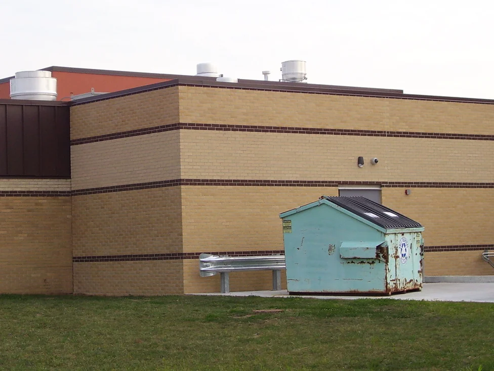 A long blank school elevation in 2005, its buff brick reading as one tone across the corner with two dark brown banding courses running the length of the wall