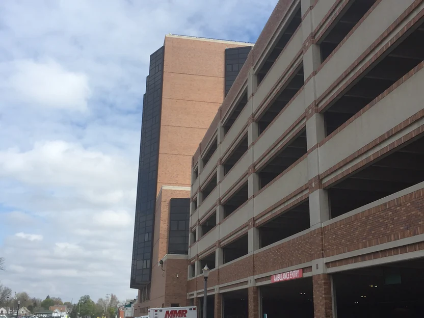 The hospital's brick and precast parking deck from the street in 2016, with the ambulance entry at the ground floor