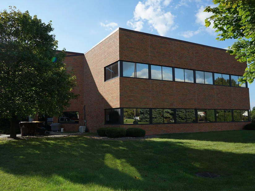 The office seen from across its front lawn in 2019, the brick reading as one red and orange range across both storeys.