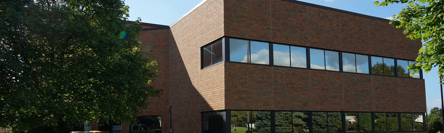 The Lansing office in 2019, its brick reading as one red and orange range beneath a dark band of ribbon windows
