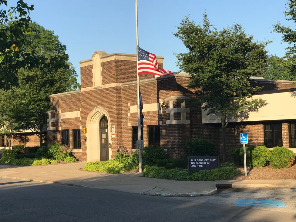 The school seen from the street corner in 2019, with the United States and Indiana flags on a pole at the entrance