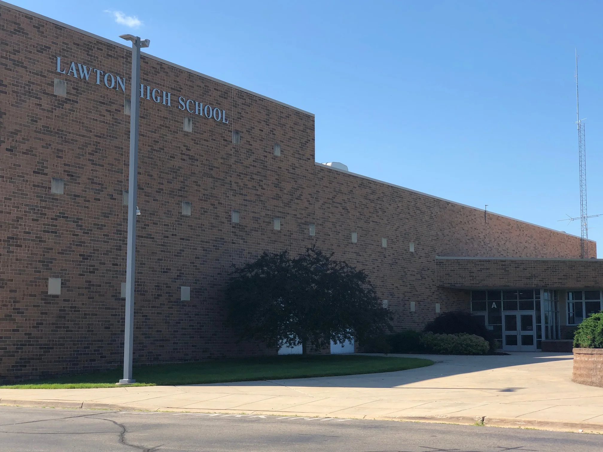 The school seen from the street in 2019, LAWTON HIGH SCHOOL lettered across the brick, the wall reading as one range along its whole length