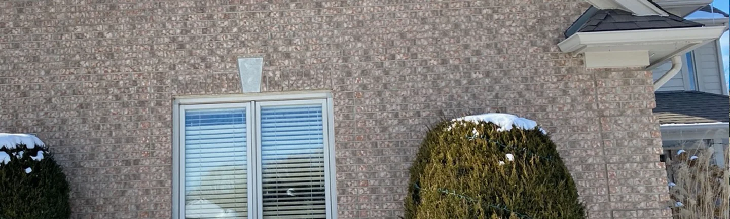 The gable end of the Leonard house in 2021, blended tan and red brick reading as one range around the window