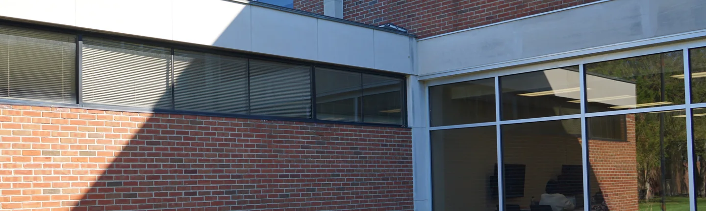 The courtyard corner of the university building in 2019, its red brick reading as one even range under a band of clerestory windows