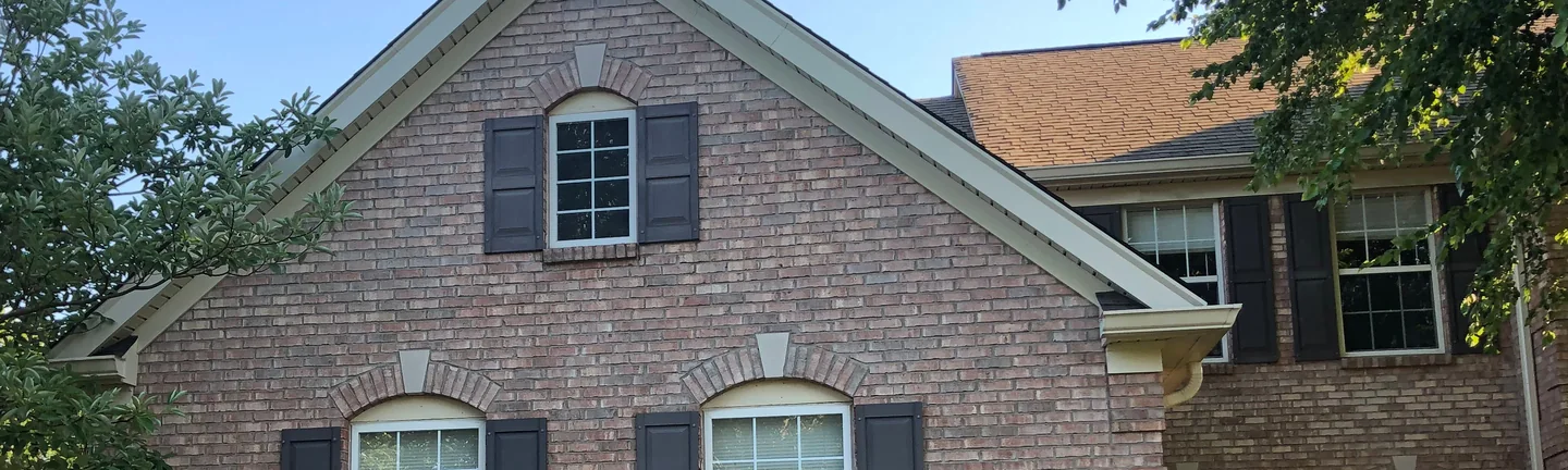 The front gable of the Louisville house in 2019, its brick reading as one varied blend of tan, pink and brown