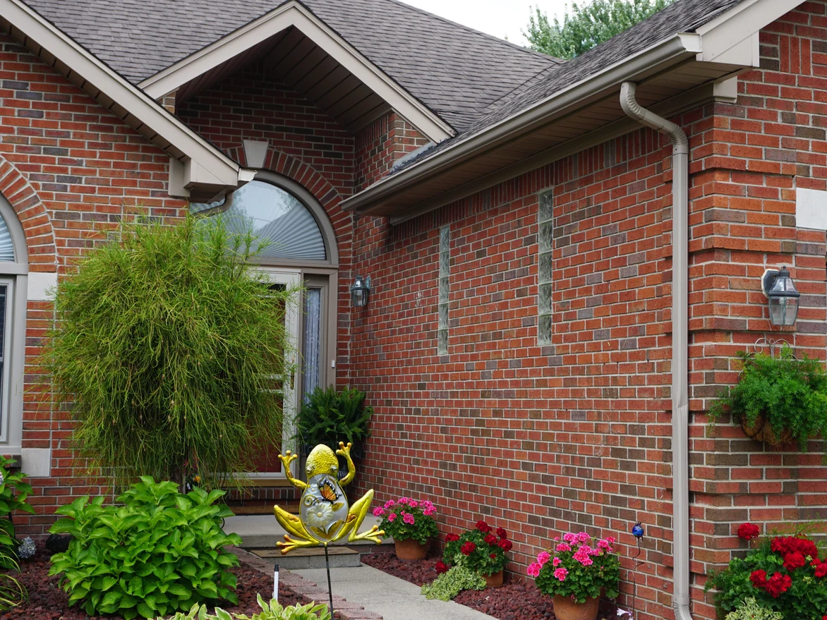 The arched entry and the side wall in 2019, the red brick one even range from the eaves down past the glass block windows