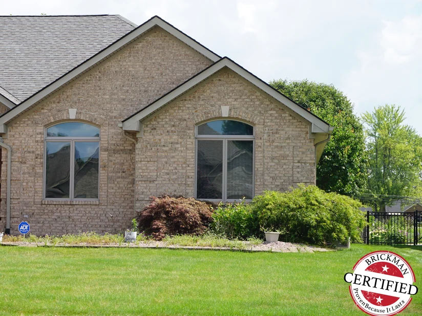 The house from the front lawn in 2019, its brick one even range of cream, buff and soft grey across both gables.