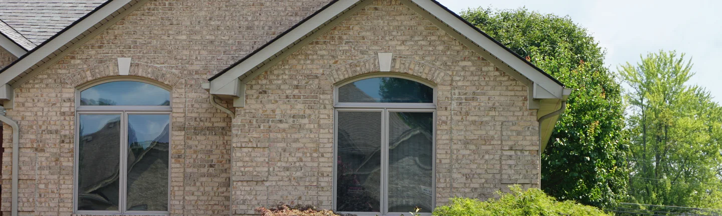 The Macomb house from the front lawn in 2019, its lightened brick reading as one even range