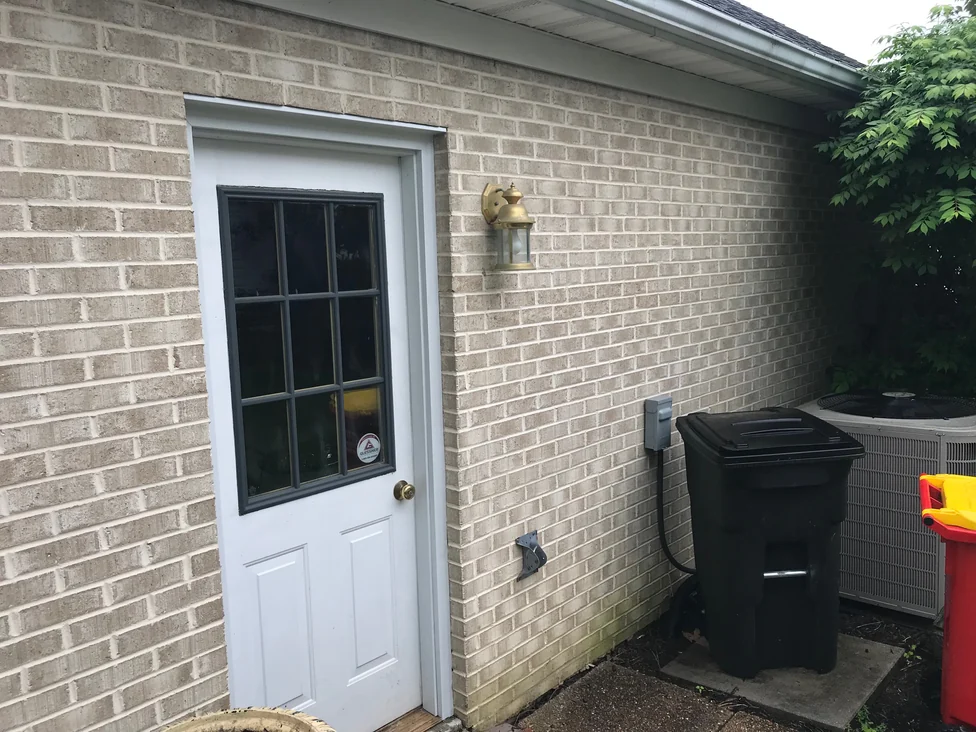 A side entry door in 2019, the brick around it one consistent color from the door frame out to the corner