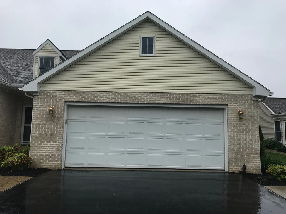 The garage front in 2019, the brick on both sides of the door carrying the same even blend