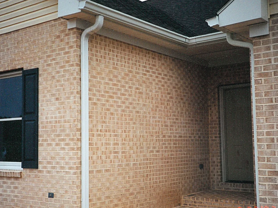 A porch corner of the house in 1997, the long wall in pale tan brick meeting a redder run of brick around the recessed entry
