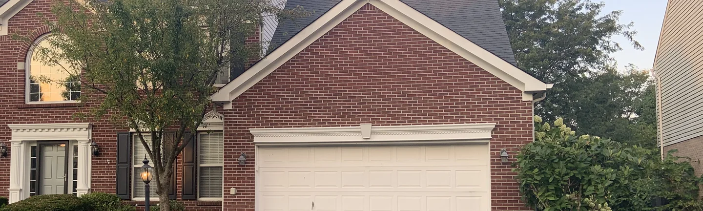 The front of the Mason home in 2019, its brick an even red range across the garage gable and the entry