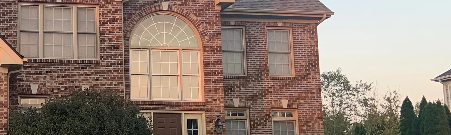The brick around the arched entry window of the house in 2019, an even range of red and brown units running past the fanlight and the windows beside it