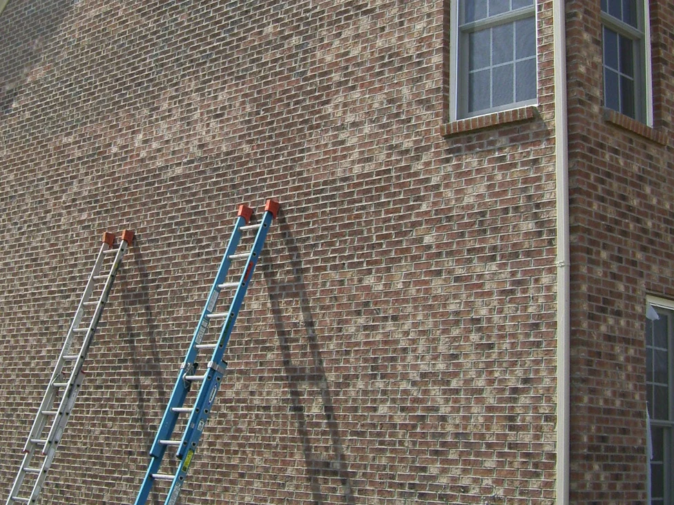 The gable end of the house during the 2008 work, two extension ladders leaned against the brick and the wall running back to the corner and its downpipe
