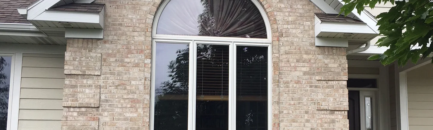 The front gable of the Mason house in 2019, its blended brick running across the wall under an arched window