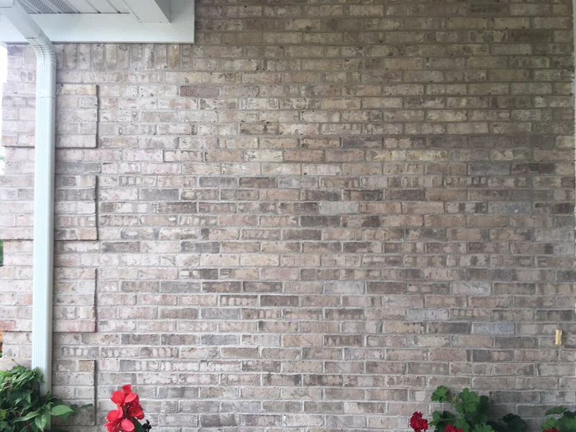 The brick wall under the covered porch in 2019, tan, grey and cream units running together with no batch standing out