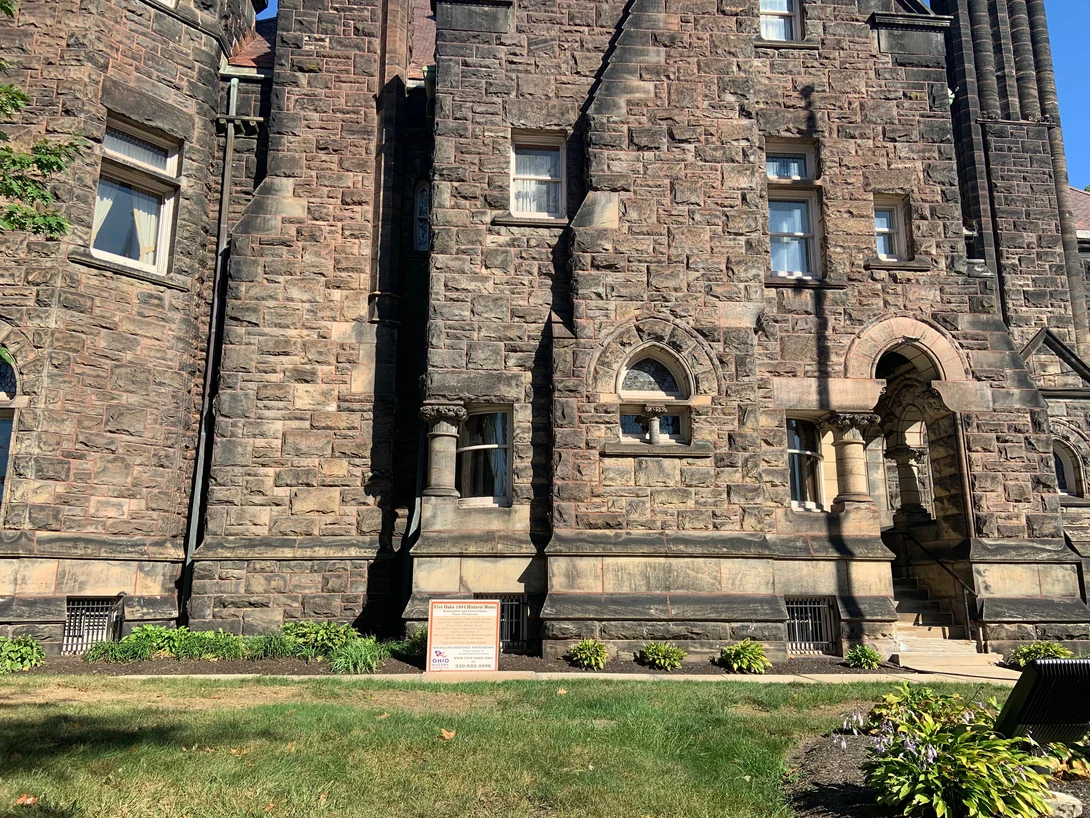The lower storey of Five Oaks in 2019, arched windows and a heavy sandstone water table reading as one consistent range