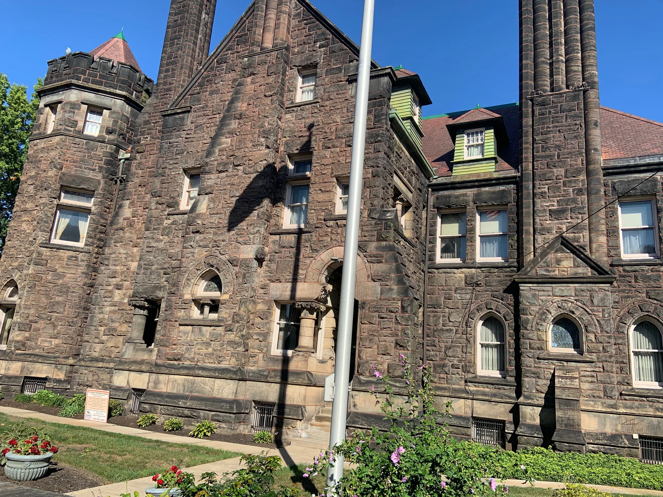 The front of Five Oaks in 2019, its rough faced sandstone reading as one range across the gable, tower and clustered chimneys