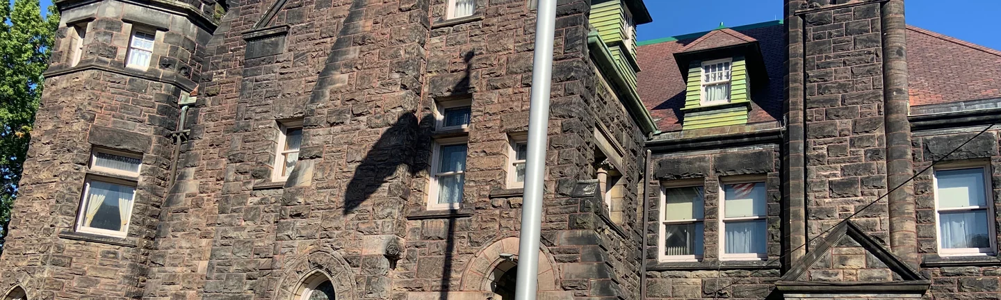 The front of Five Oaks in 2019, its rough faced sandstone reading as one range across the gable, tower and clustered chimneys