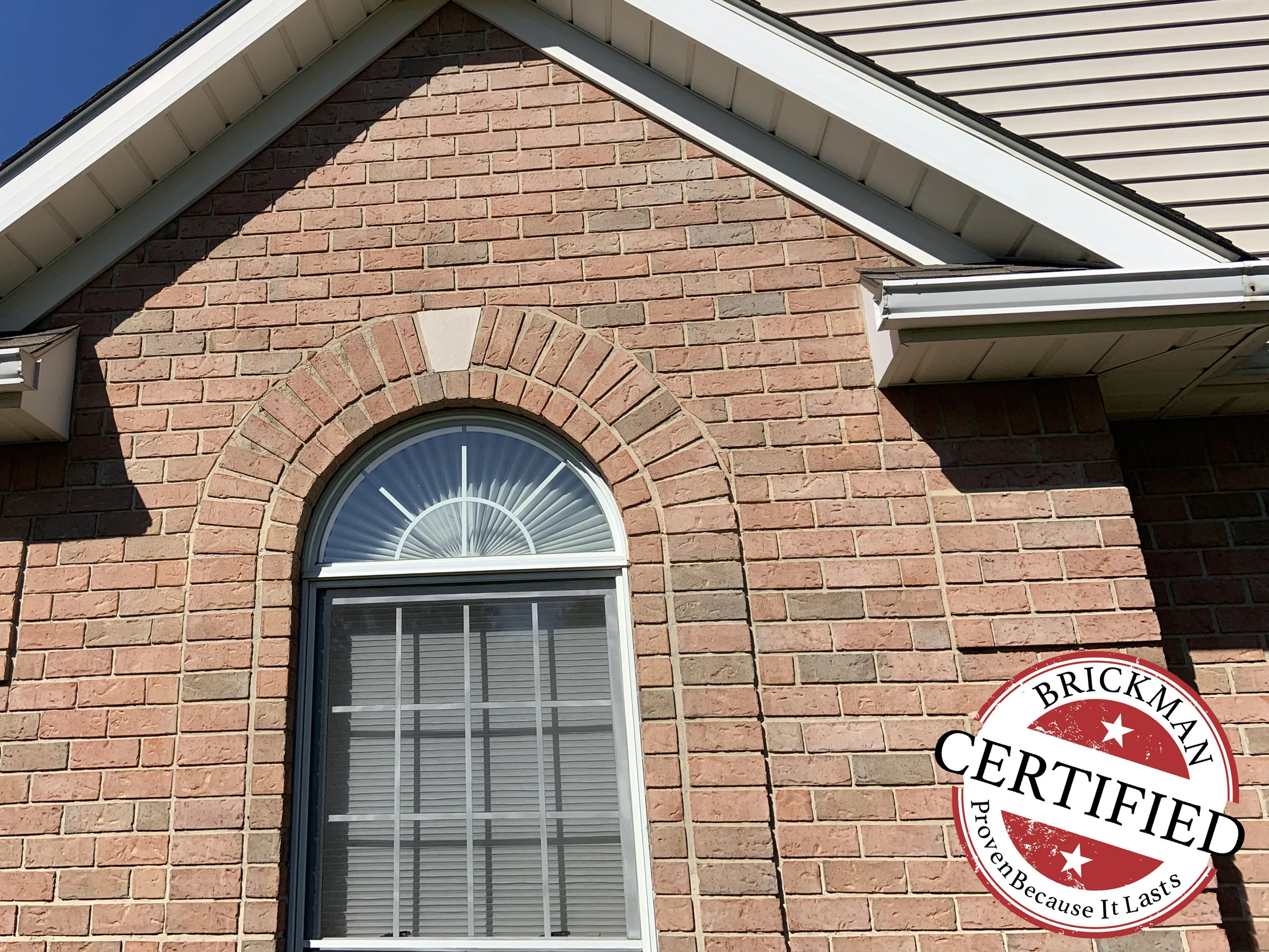 The arched attic window in its brick surround in 2019, the soldier arch and the wall around it reading as one even range