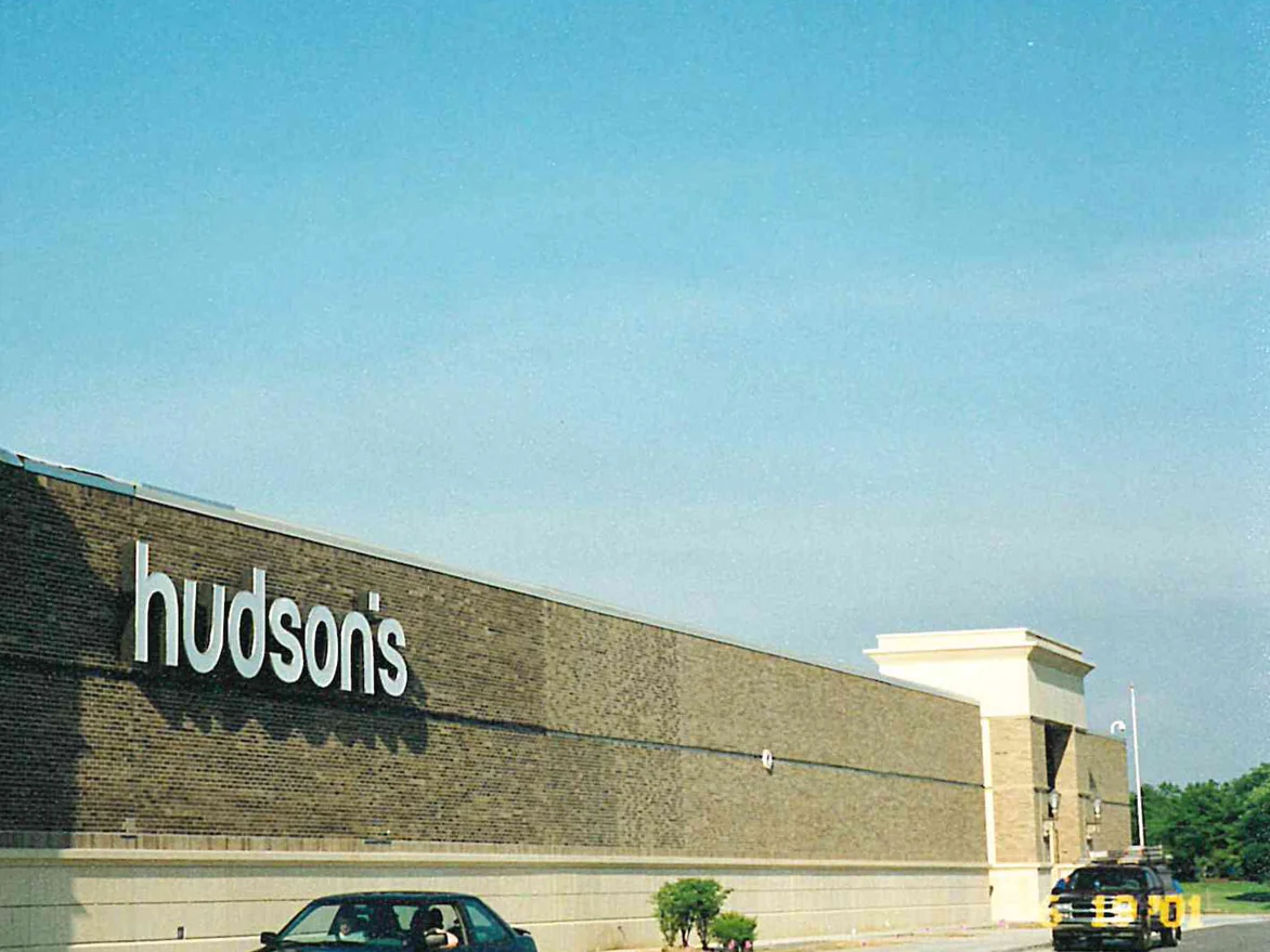 The long anchor store wall in 2001, its darker brick running the length of the elevation to a lighter tan entrance tower and base course at the far end, a store sign fixed high on the wall
