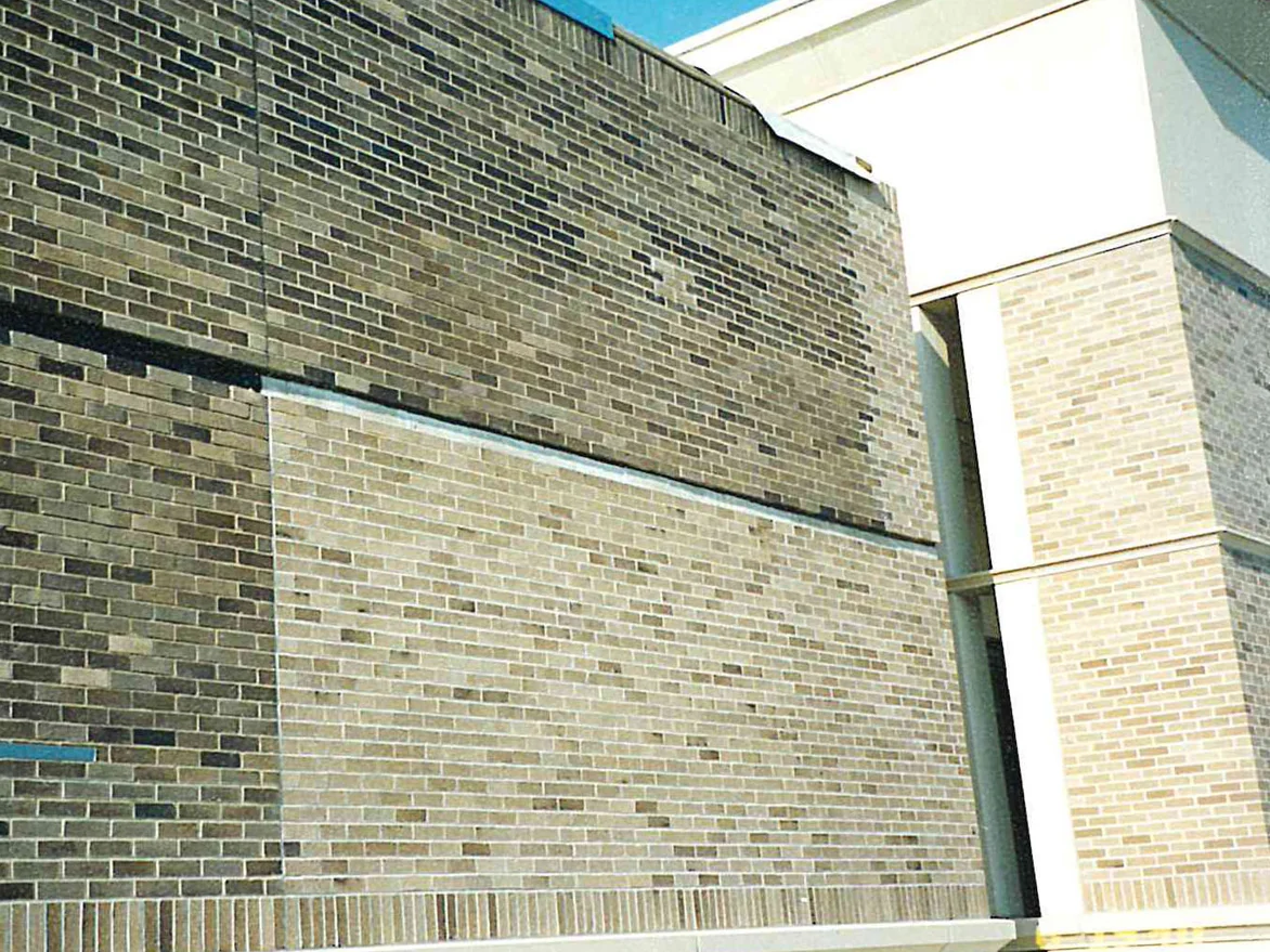 The wall at close range in 2001, a band of darker brown brick above and lighter buff panels below and alongside it, the ranges reading as separate colors across the junction