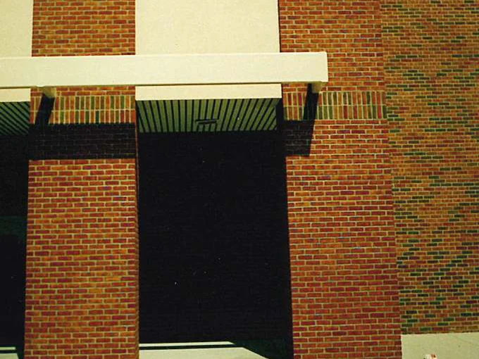 The entrance canopy and doorway in 1995 before staining, the plain orange brick of the piers meeting the darker flashed blend of the wall to the right