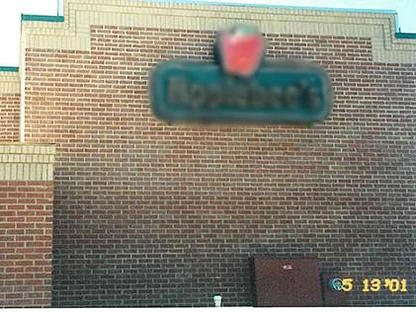 The wall under the restaurant sign in 2001, dark red brick blotched with lighter units and stepped buff bands above, with a camera date of 5/13/01 burned in