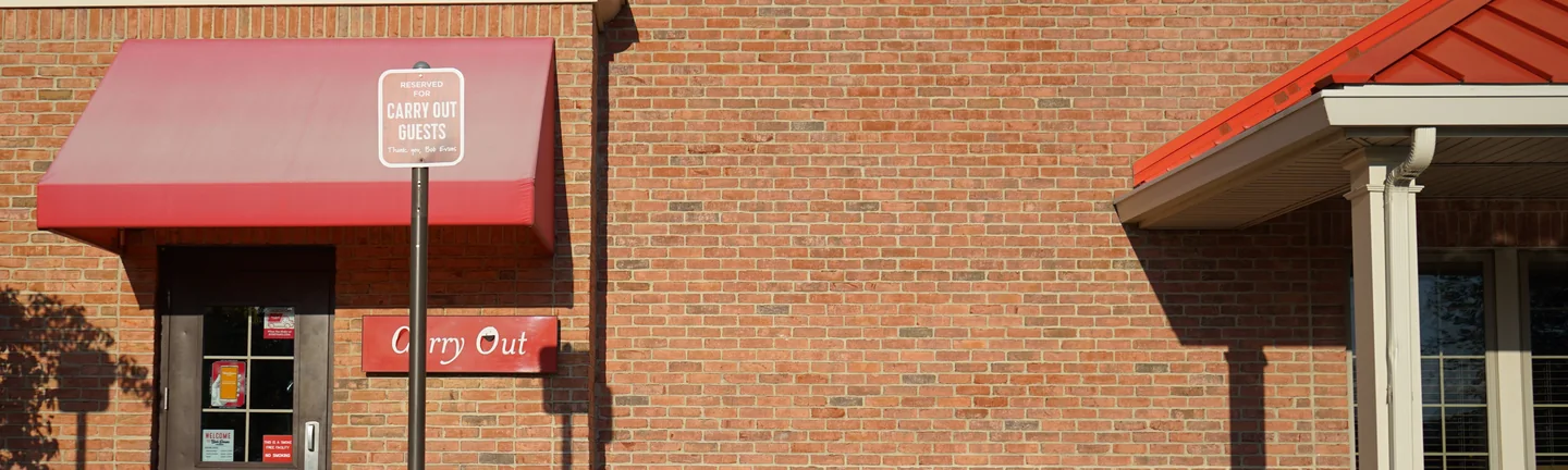 The carry out elevation of the restaurant in 2019, its brick reading as one even red and brown wall