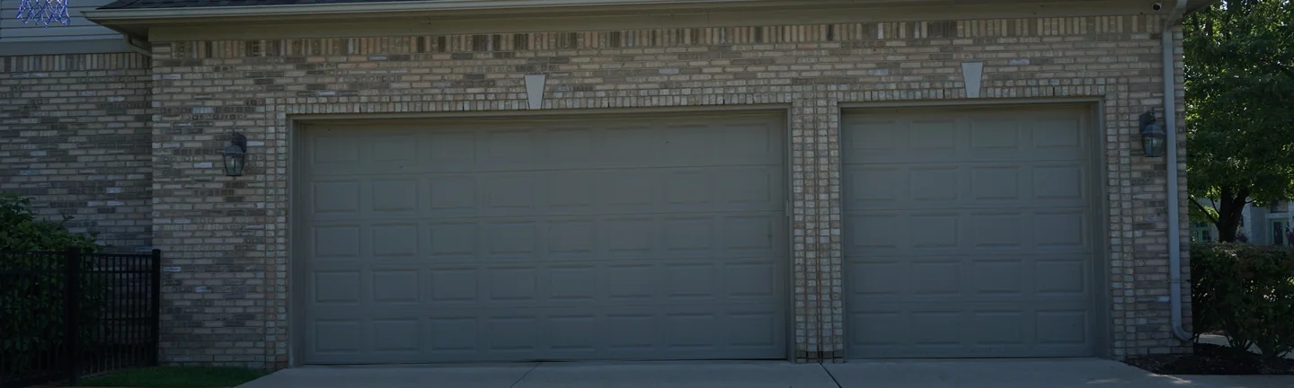 The garage elevation of the Michigan house in 2019, its brick an even salmon and tan range under a hipped roof