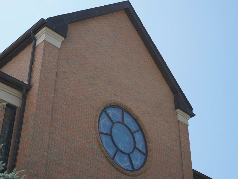 The outside corner of the gable from below in 2019, the pier and the wall face carrying the same blend of red and brown units