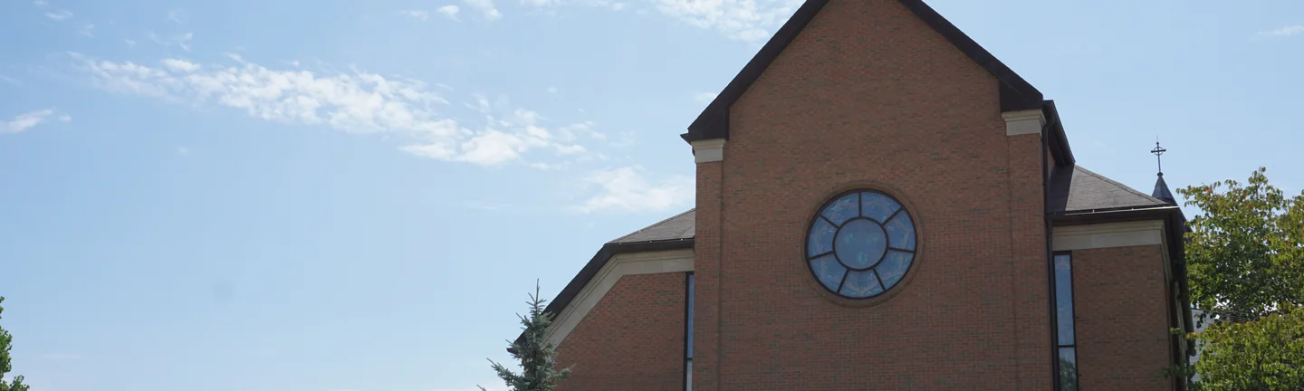The Michigan church from the lawn in 2019, its brick reading as one even range across the gable and the main wall