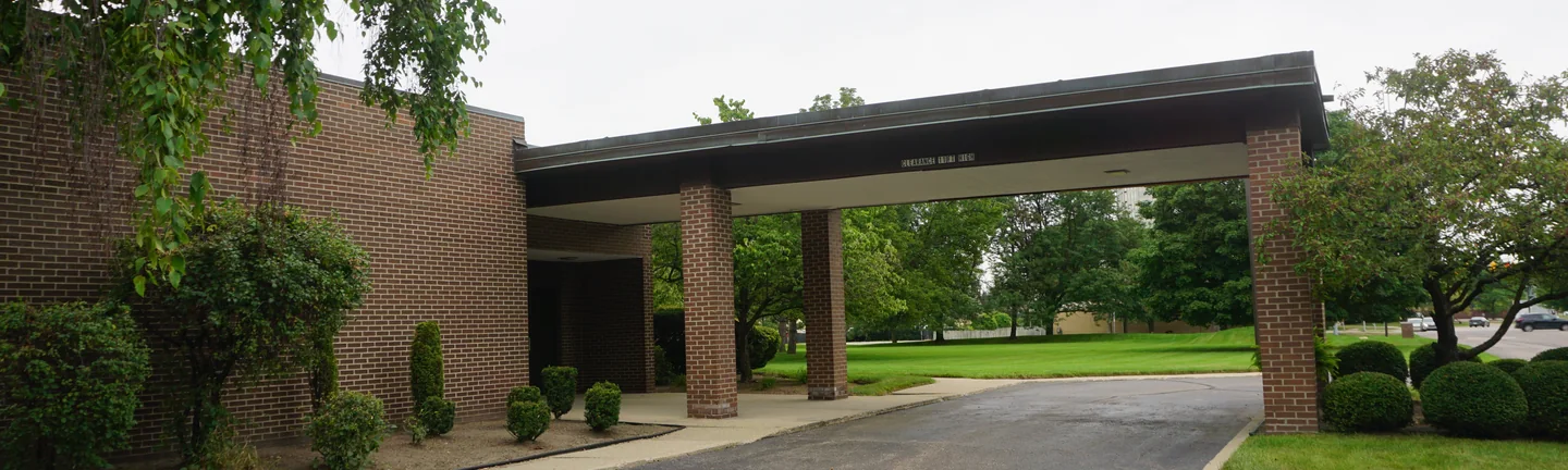 The church's drive-through entrance canopy in 2019, carried on brick columns that read with the walls behind them