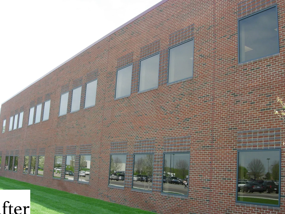 The long two story elevation seen down its length, the window bands and the soldier courses between them reading as one red brick range