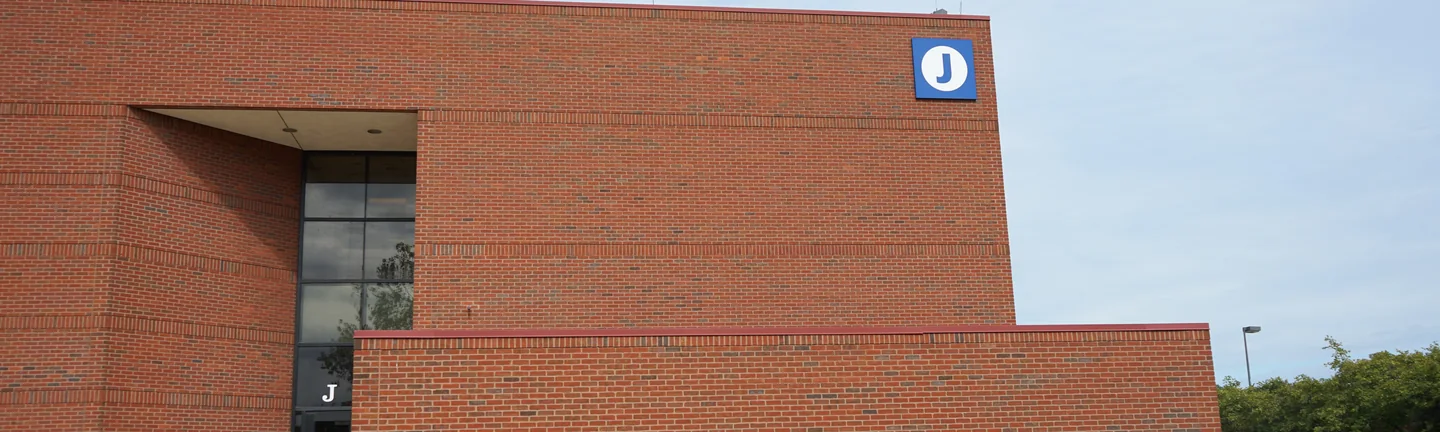 The end wall of the college building in 2019, its field brick and soldier courses reading as one red range