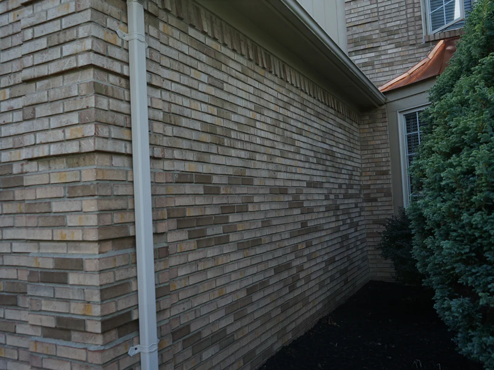 A raking view along the side wall in 2019, the brick an even buff and tan range running back to a soldier course under the eaves