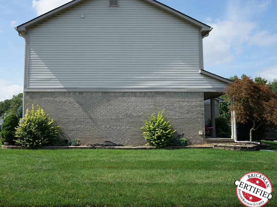 The same gable end twenty-one years later, the brick reading as one grey range with no patches standing out from it