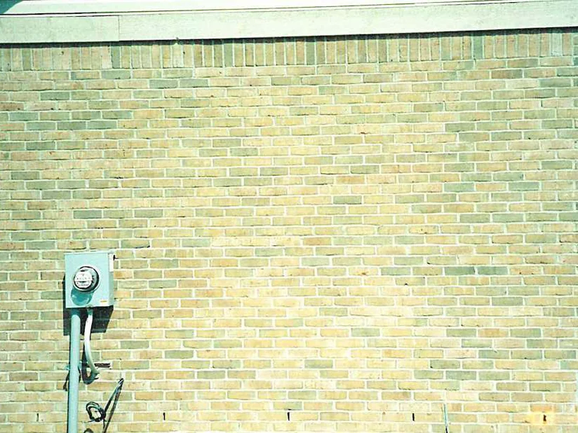 The same side wall in 2003 after the light brick were darkened, the blend reading evenly around the electric meter with no pale units standing out