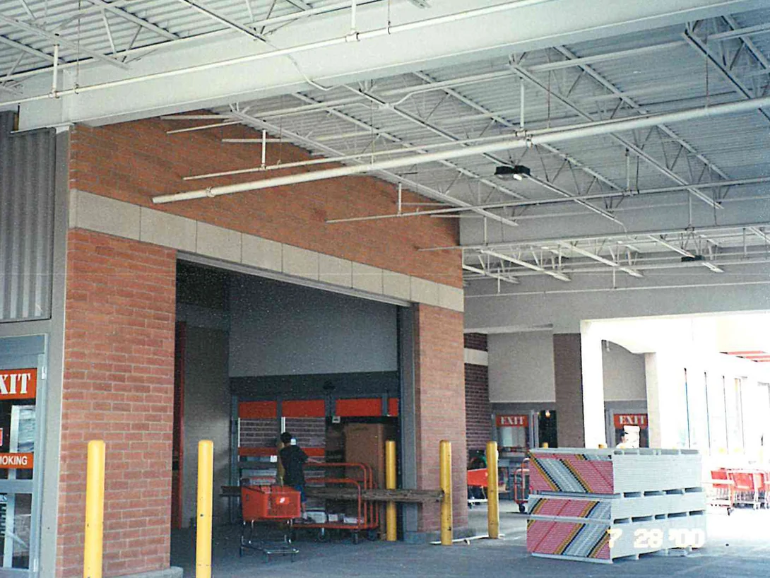 A canopy bay in 2000 after staining, the pier and the brick above the opening both reading as one red brown, with the store's exit doors at the left