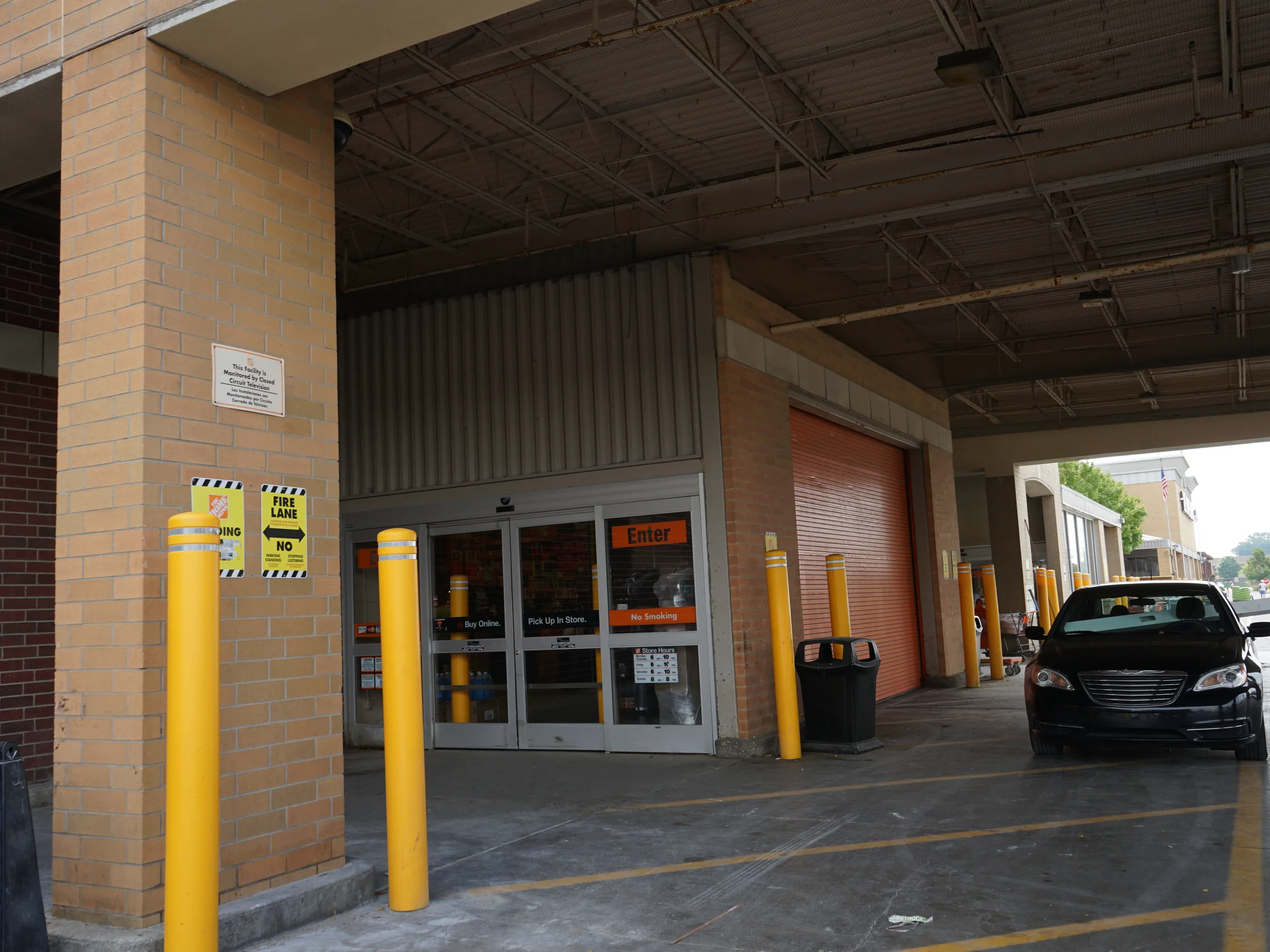 The covered entrance drive in 2019, the near pier and the piers beyond it reading as one brick range past the entry doors