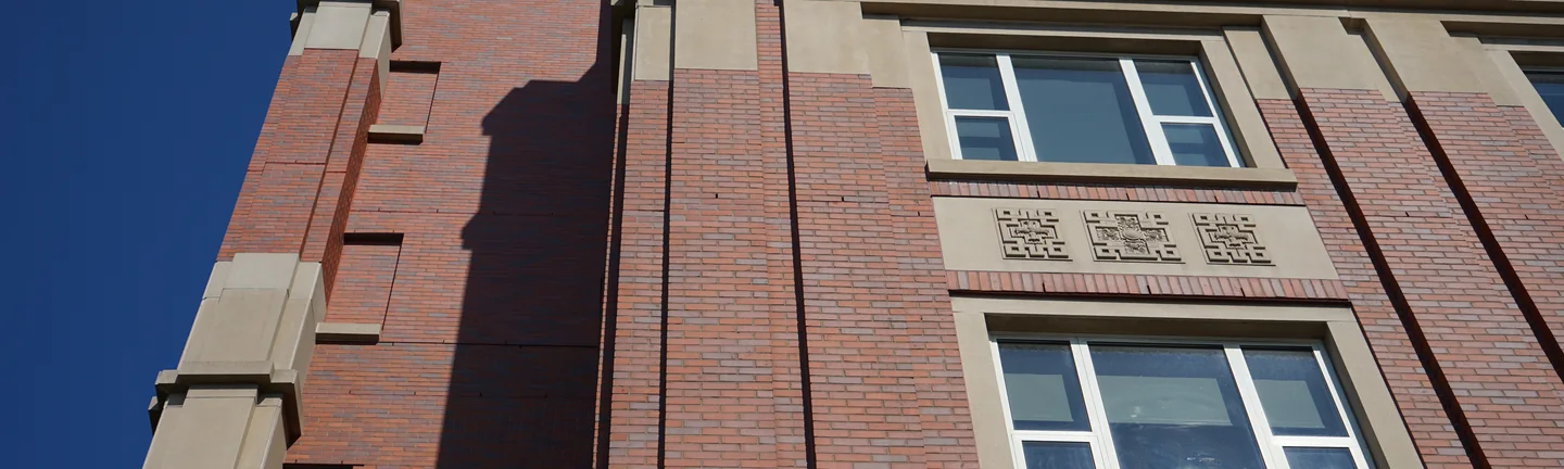 Red brick piers and cast stone panels of geometric ornament on the hospital's upper floors in 2019